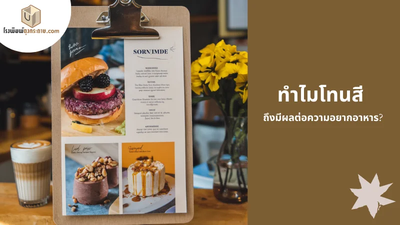 ป้ายเมนูอาหารที่มีภาพประกอบของเบอร์เกอร์และขนมหวานต่างๆ วางบนกระดานไม้ขนาดเล็ก มีดอกไม้สีเหลืองอยู่ด้านข้าง